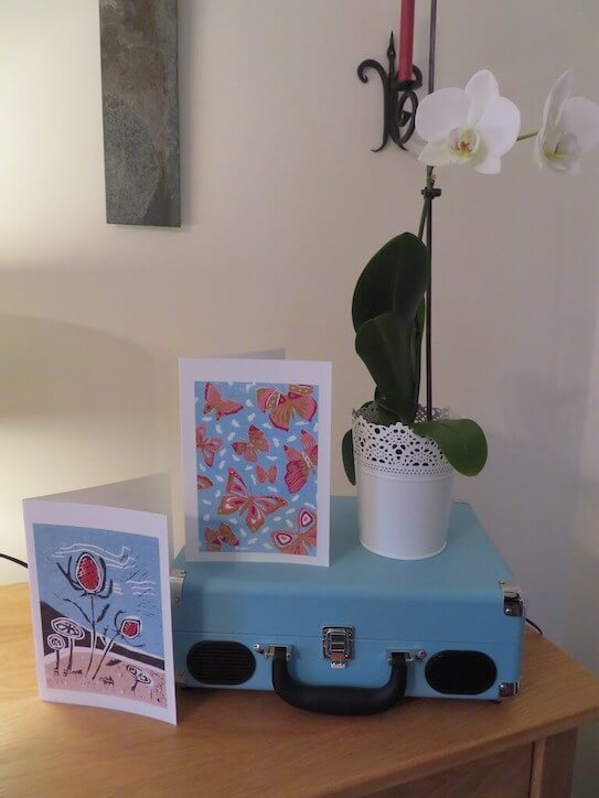 Two lino print greetings cards titled 'Beach Seedhead' and 'Butterfly Skies'.